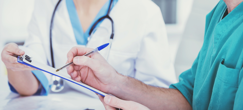 Doctors writing on a clipboard