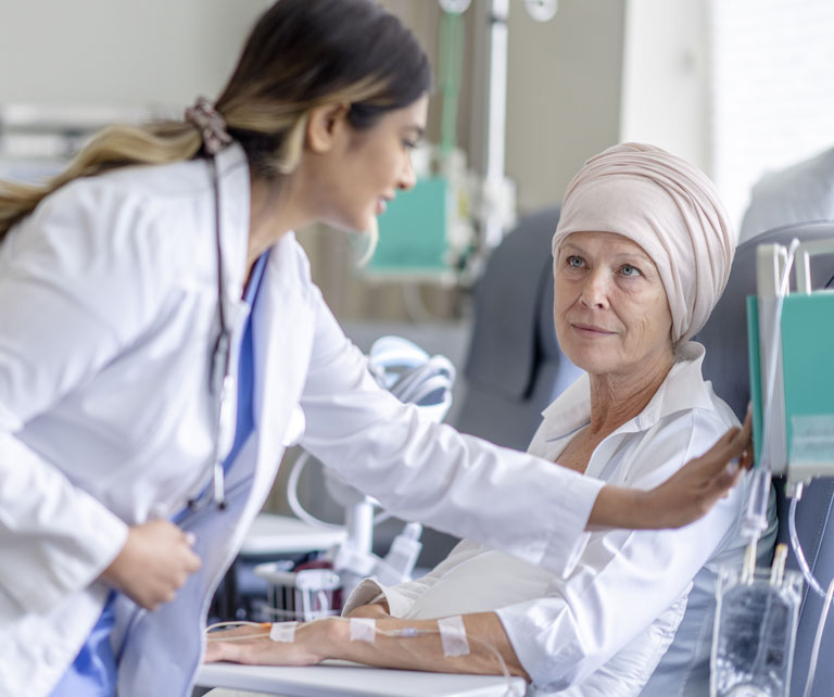 A woman being assisted by a doctor while undergoing chemotherapy